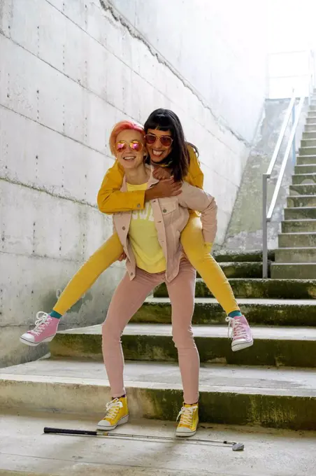 Two alternative friends having fun, wearing yellow and pink jeans clothes