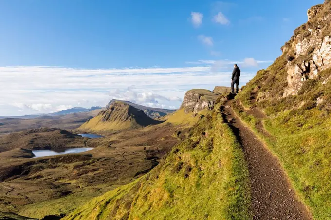 UK, Scotland, Inner Hebrides, Isle of Skye, Trotternish, hiking trail at Quiraing, Loch Cleat, hiker looking at view