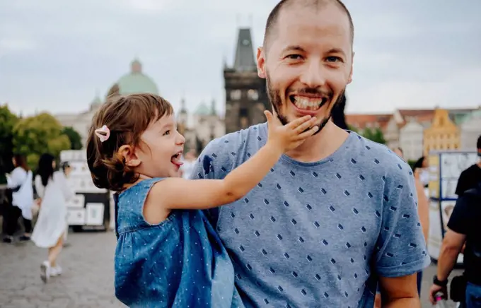 Czechia, Prague, father and little daughter having fun together on Charles Bridge