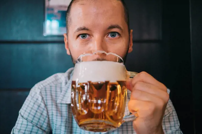 Czechia, portrait of man drinking beer in a pub