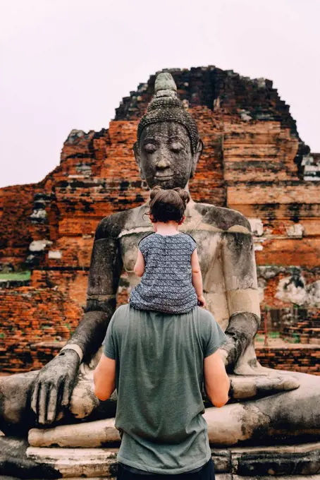 Thailand, Ayutthaya, Father and daughter looking at a Buddha statue at Wat Mahathat