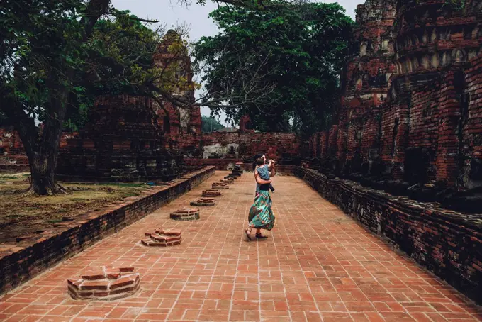 Thailand, Ayutthaya, Mother and daughter dancing in the ancient ruins of a temple at Wat Mahathat