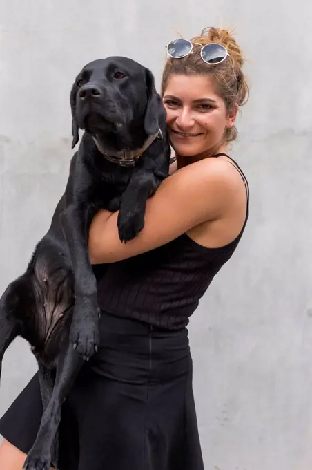 Portrait of happy young woman with her black dog