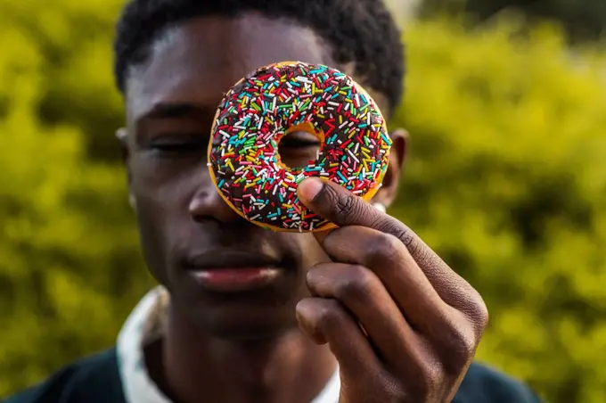 Young black man holding a chocolate cookie
