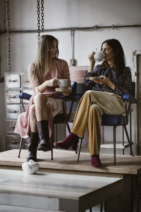 Two friends drinking tea together in a loft