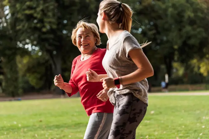 Granddaughter and grandmother having fun, jogging together in the park