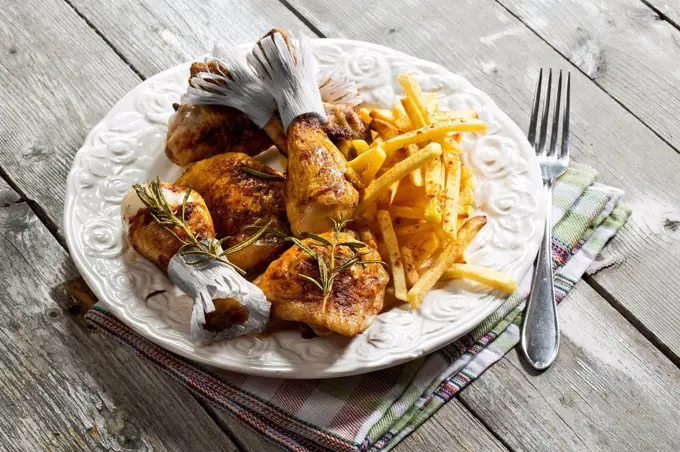 Chicken drums with french fries on plate