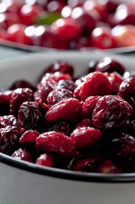 Two bowls of dried and fresh cranberries (Vaccinium macrocarpon), close-up