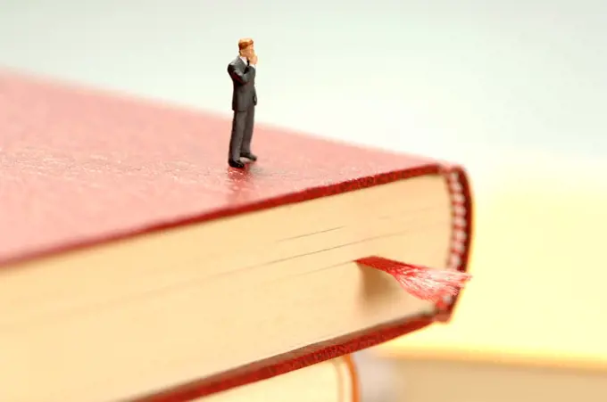 Figurine of man kept on book, close-up