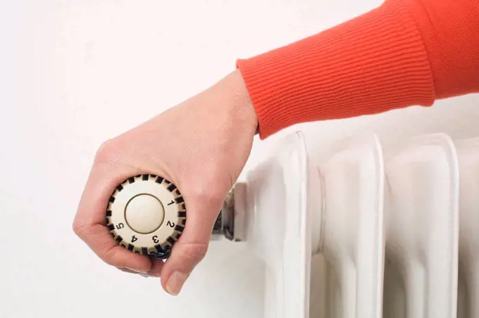Female hand on thermostat