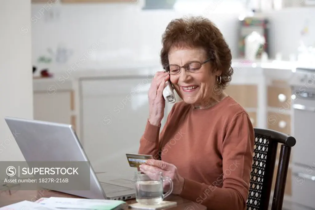 Senior woman paying bills on the telephone