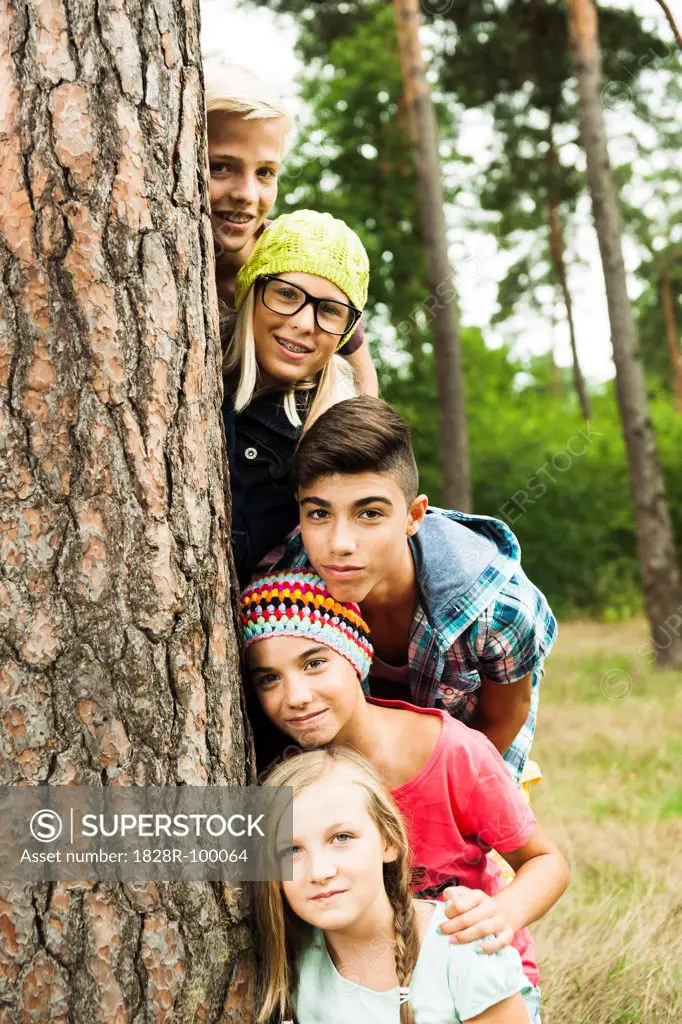 Portrait of group of children posing next to tree in park, Germany. 08/31/2013