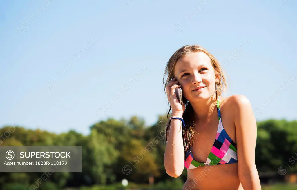 Girl using Cell Phone at Beach, Lampertheim, Hesse, Germany. 09/06/2013