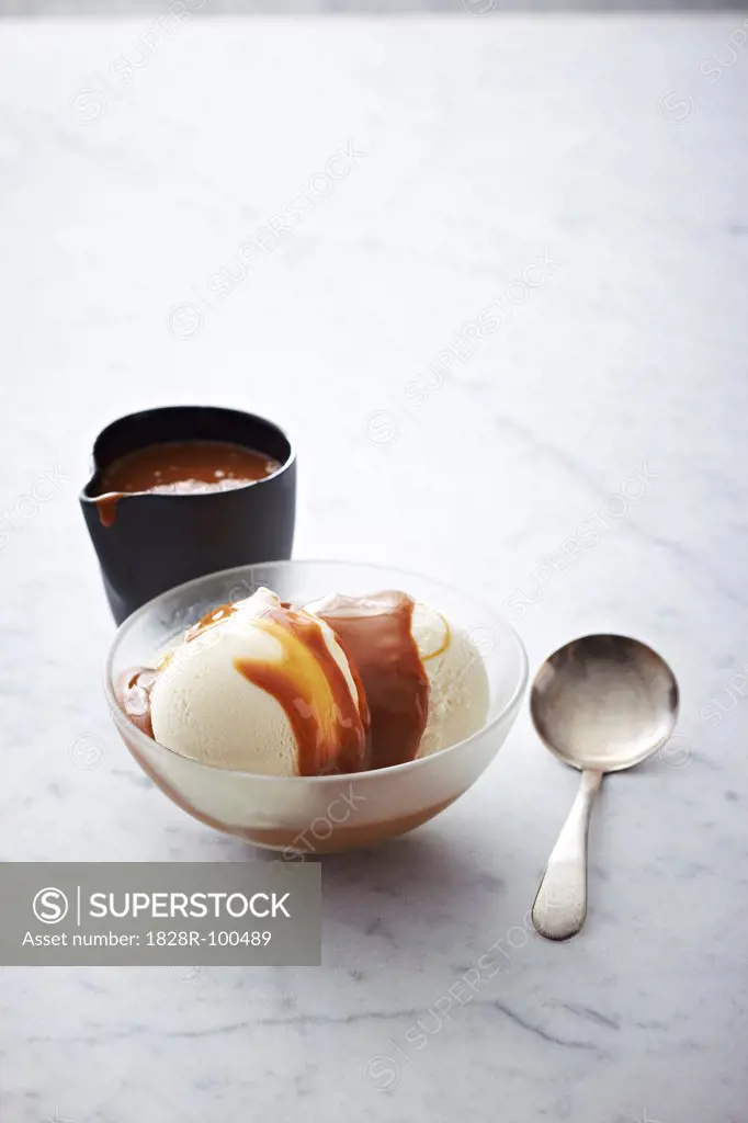 Vanilla Ice Cream with caramel sauce in bowl with spoon, studio shot. 01/25/2012