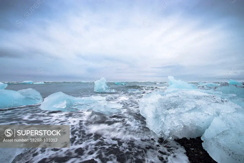View of the glacial lagoon, landscape with blue iceberg, foaming sea and cloudy blue sky, Jokulsarlon, Skaftafell, Iceland. 07/05/2013