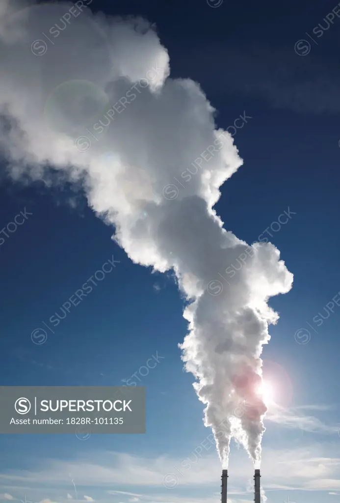 Industrial smoke stacks with steam billowing into blue sky, Toronto, Ontario, Canada. 01/22/2014