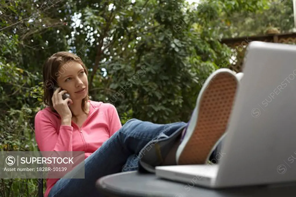 Woman Sitting Outside Talking On Cell Phone   