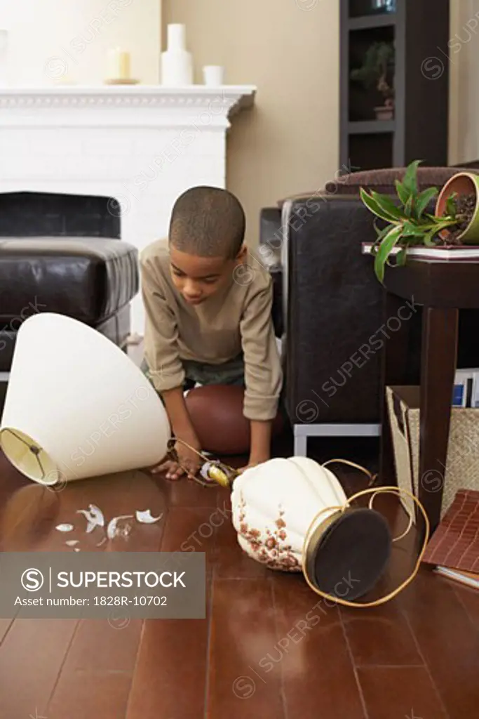 Boy Looking at Broken Lamp   
