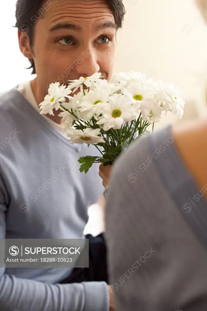 Man Smelling Bouquet of Flowers   