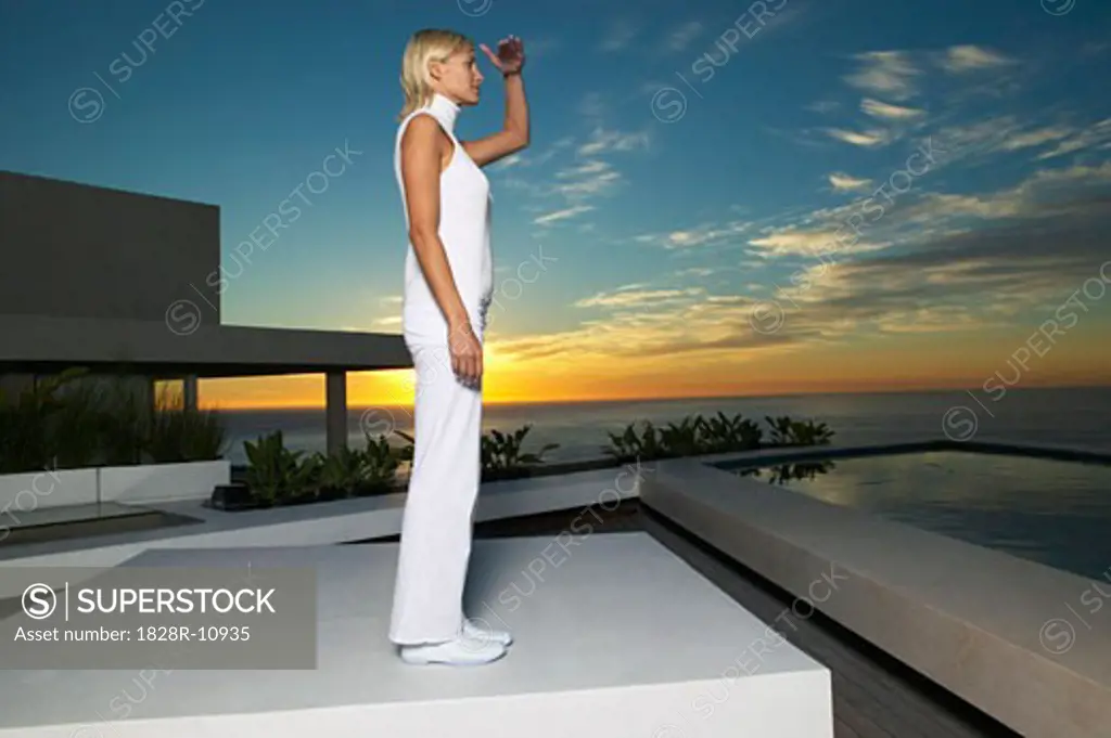 Woman Standing on Patio, Looking at Ocean   