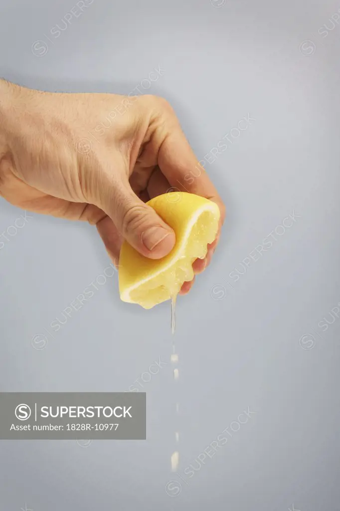 Person's Hand Squeezing Lemon   