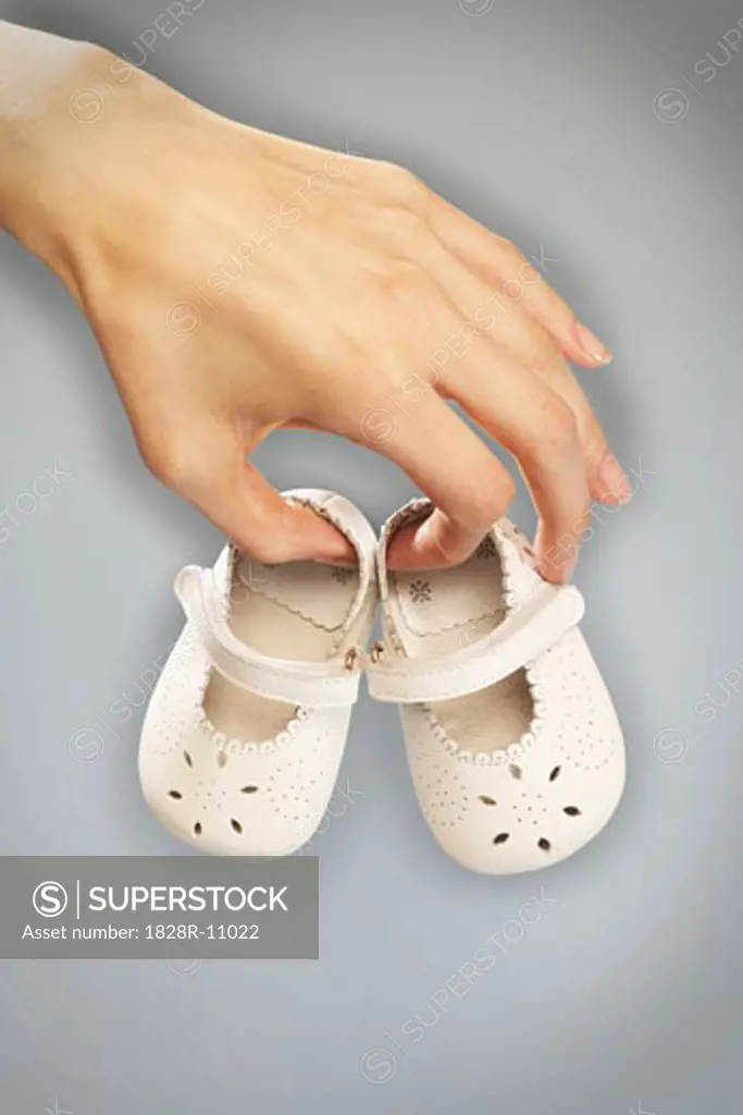 Hands Holding Baby Shoes   
