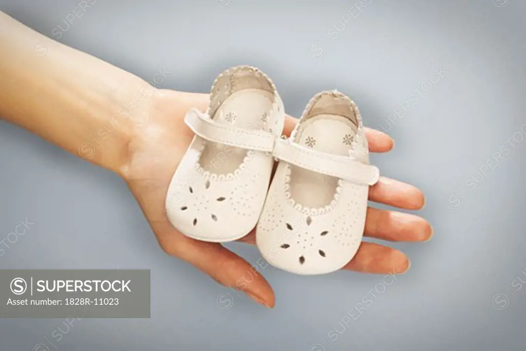 Hands Holding Baby Shoes   