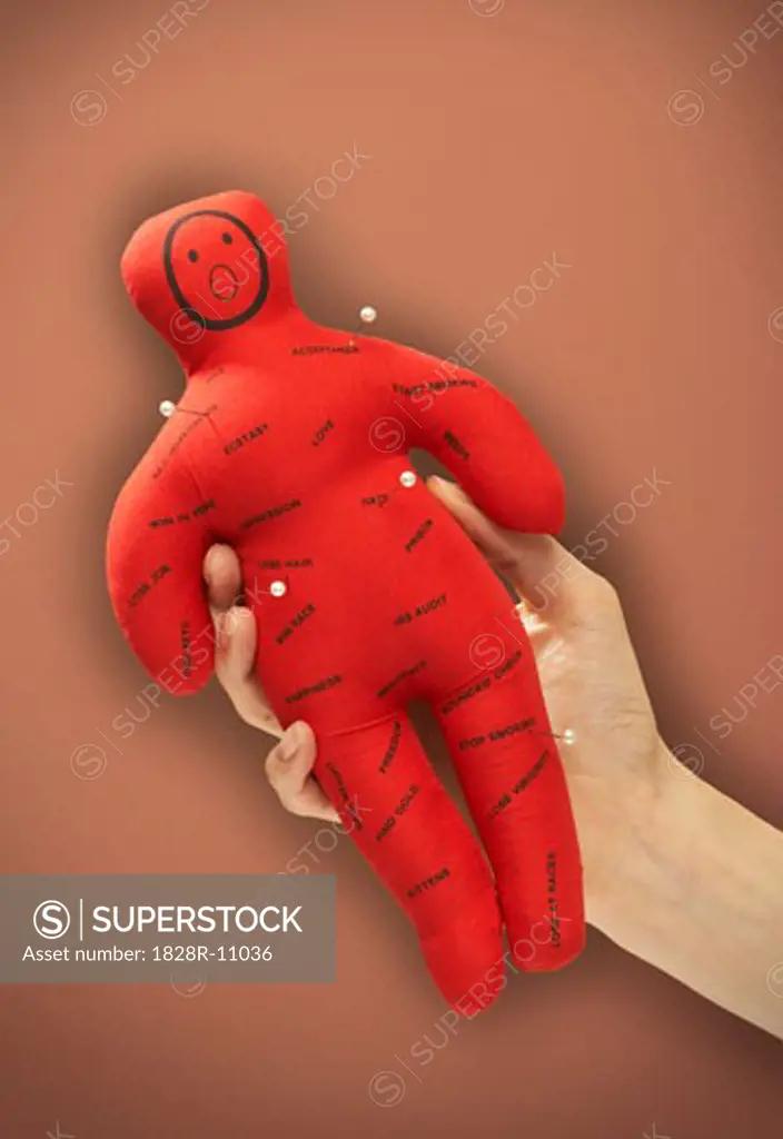 Person's Hand Holding Voodoo Doll   