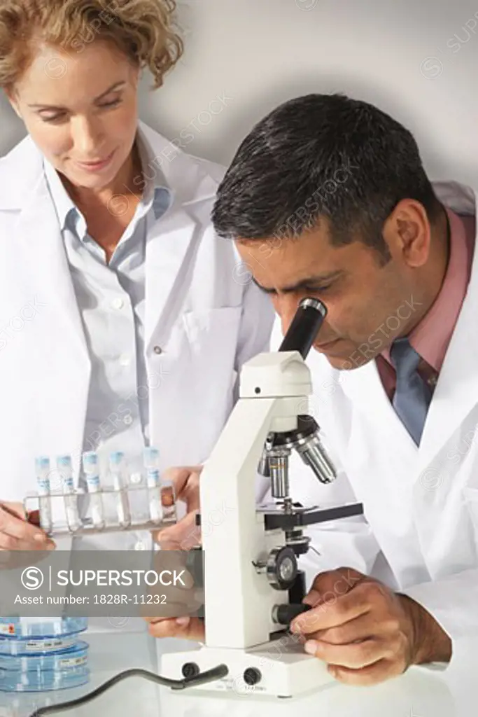 Doctors Looking Into Microscope   