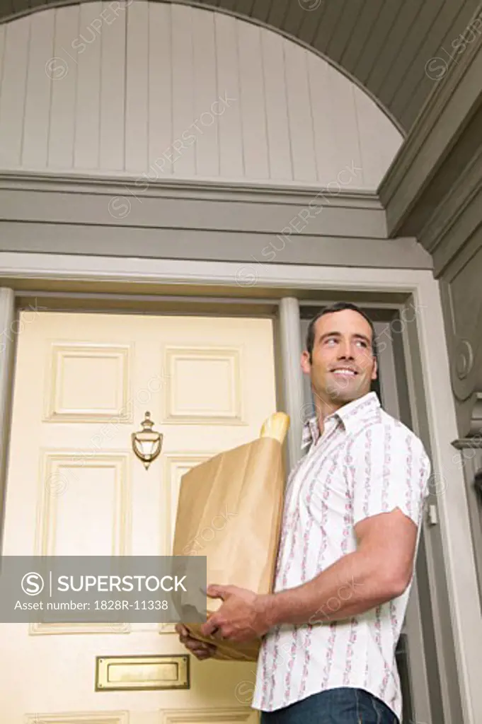 Man in Front of Home with Groceries   