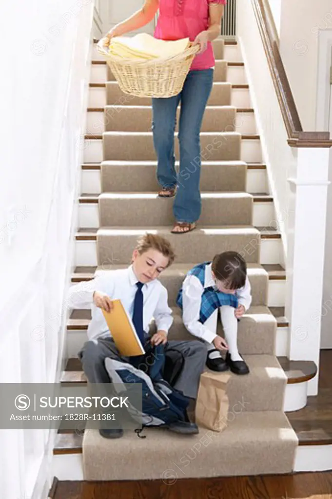 Children Getting Ready for School while Mother does Laundry   