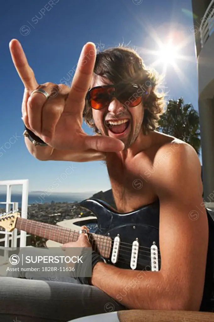 Portrait of Man With Guitar, Making Hand Gesture   