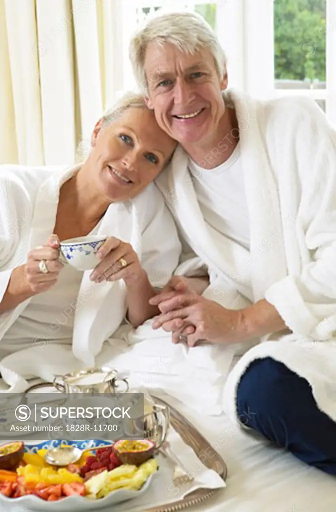 Mature Couple Eating Breakfast In Bed   