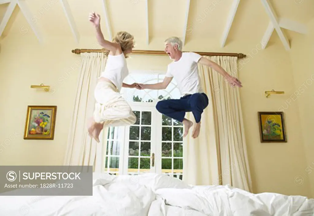 Couple Jumping On Bed   