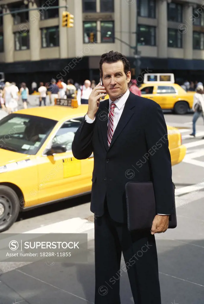 Businessman with Cellular Phone on Sidewalk   