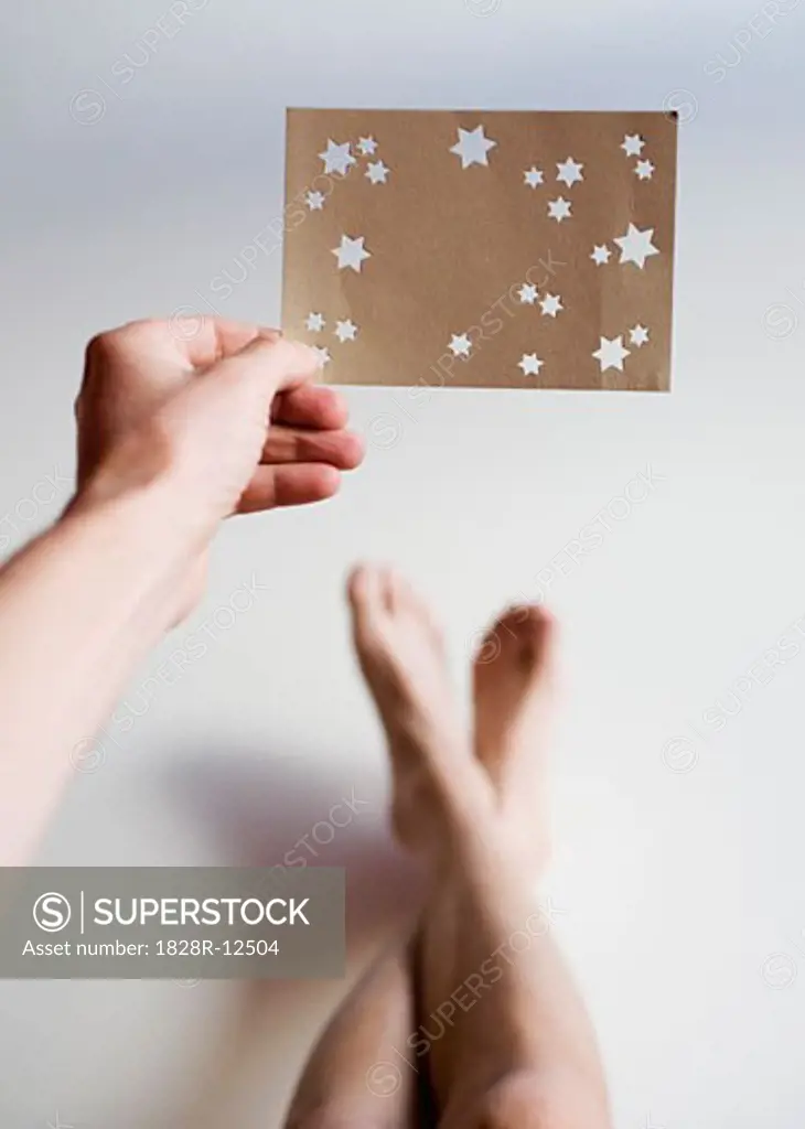 Person Holding Paper with Star Cut-Outs   