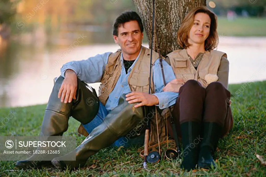 Portrait of Couple Sitting Under a Tree, With Fishing Gear   
