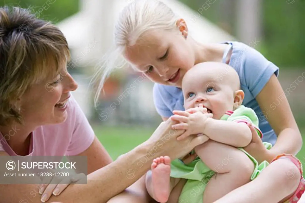 Mother and Daughter Playing with Baby   