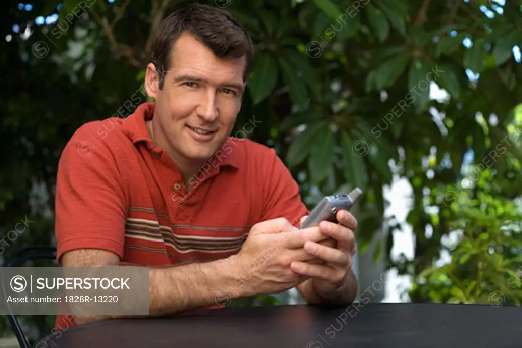 Man Holding Cell Phone Outdoors   