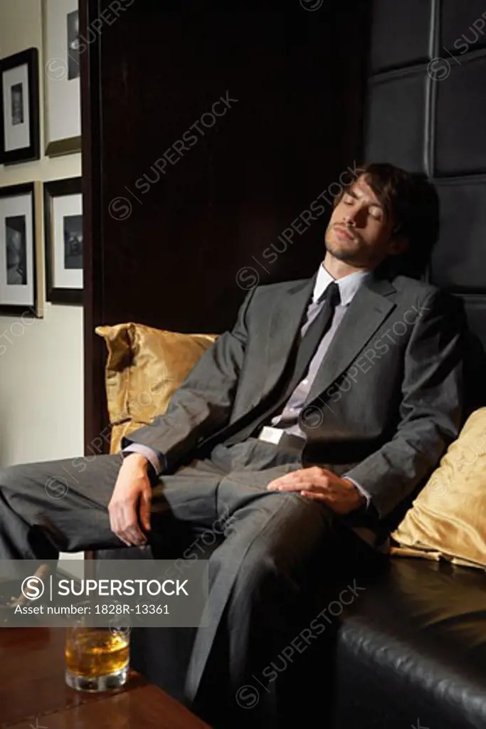 Man Asleep on Sofa with Cigar and Liquor   