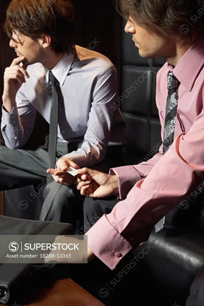 Businessmen Exchanging Microchip   