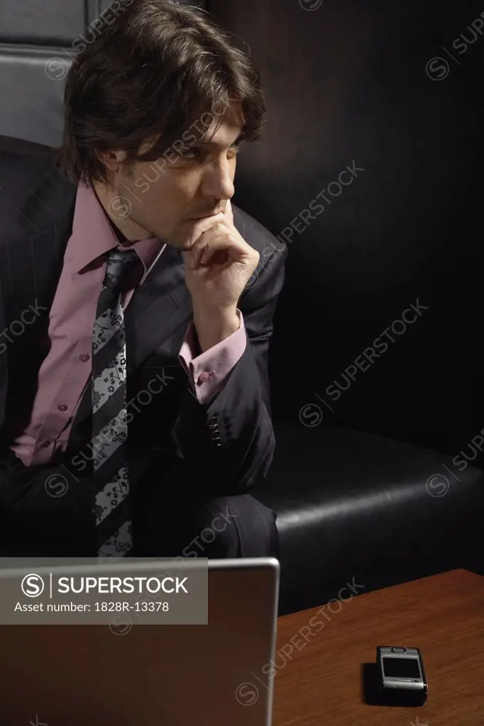 Businessman with Laptop Computer and Cellular Phone   