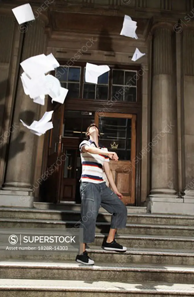 Student Throwing Papers in Air By School   