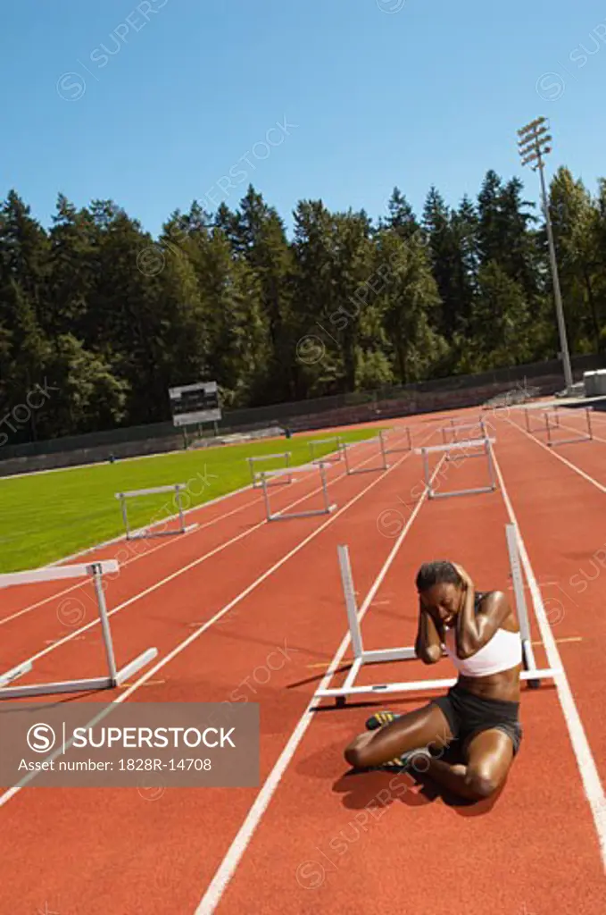 Woman Sitting on Running Track after Stumbling   