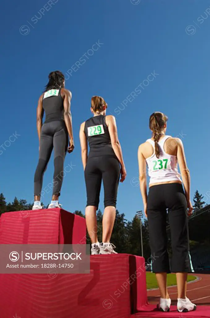 Champion Athletes Standing on Podium   