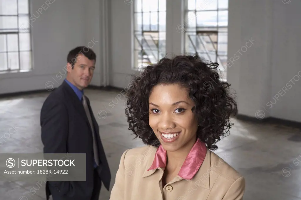 Portrait of Businesswoman with Businessman in Background   