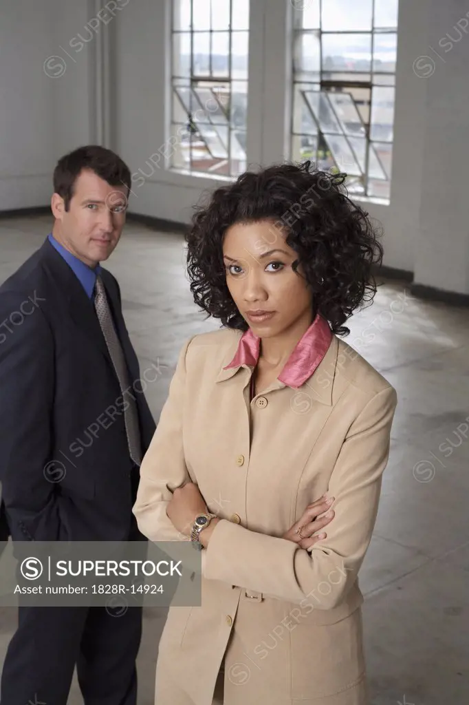 Portrait of Businesswoman with Businessman in Background   