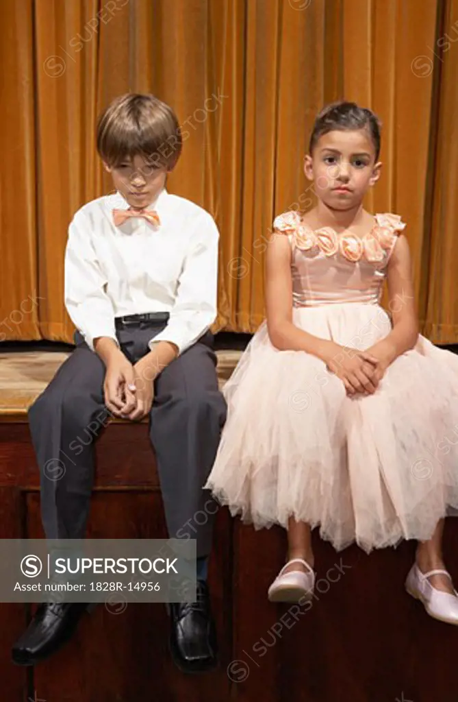 Boy and Girl Sitting on Stage   