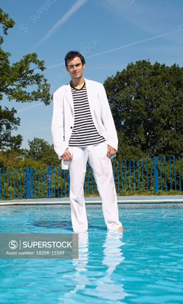 Man Wading in Swimming Pool with his Clothes on   