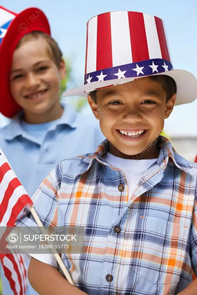 Portrait of Boy Wearing Stars and Stripes Hat Holding Flag   